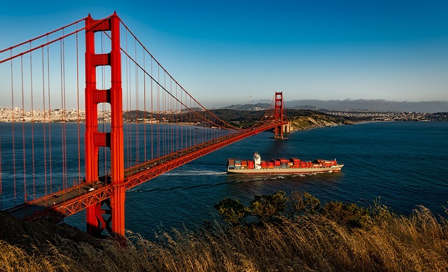 A container ship going under the Golden Gate Bridge in San Francisco on a sunny day