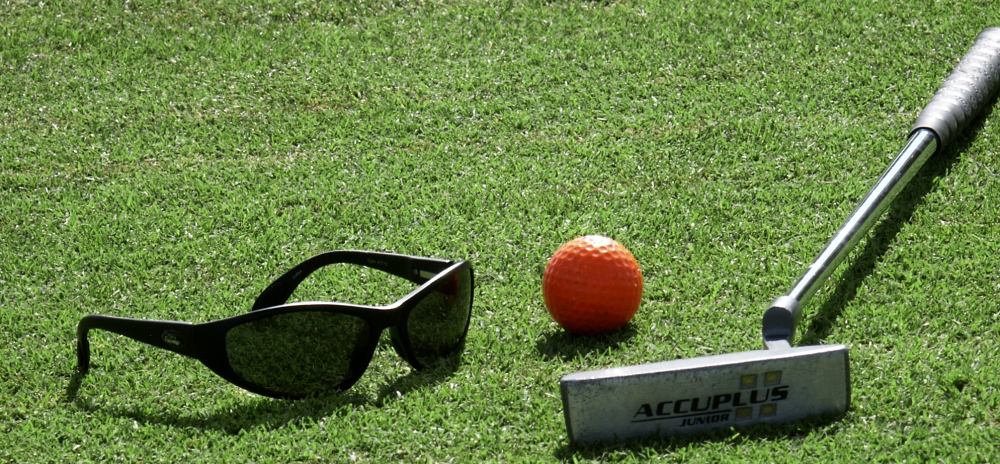 Golf club, golf ball and sunglasses