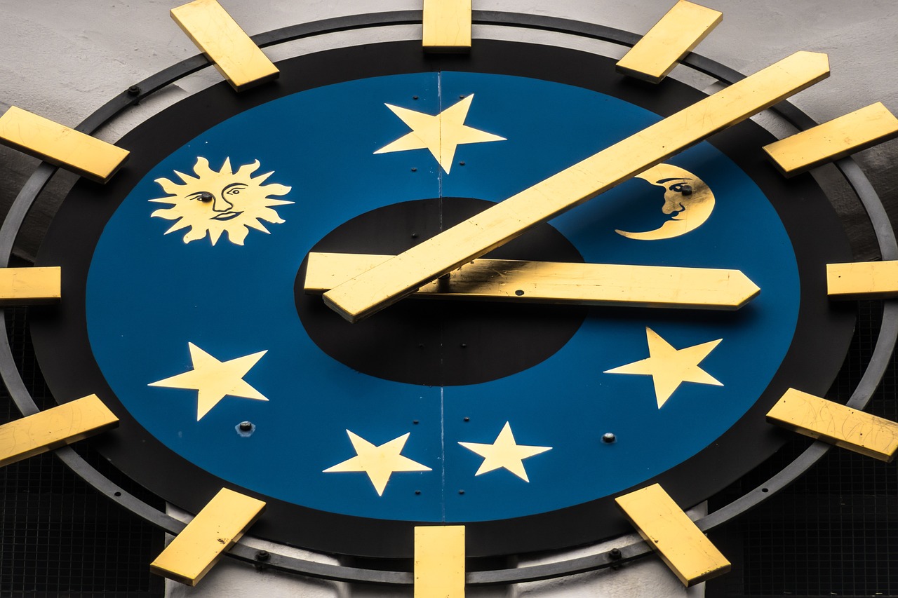 a blue clock face with golden hands